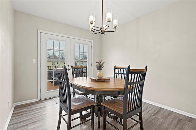 dining room featuring dark wood-type flooring, an inviting chandelier, and french doors