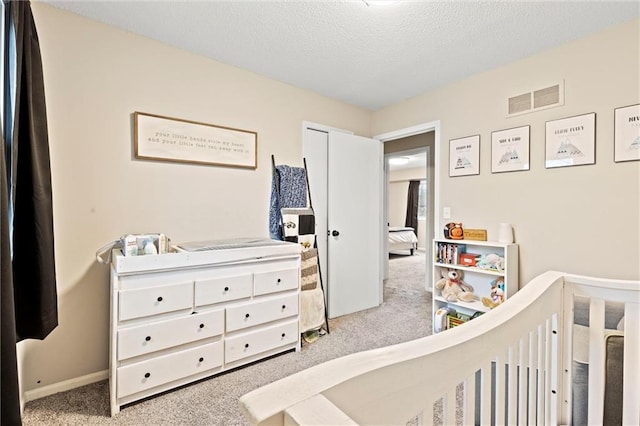 carpeted bedroom featuring a textured ceiling