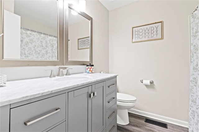 bathroom featuring vanity, hardwood / wood-style flooring, and toilet