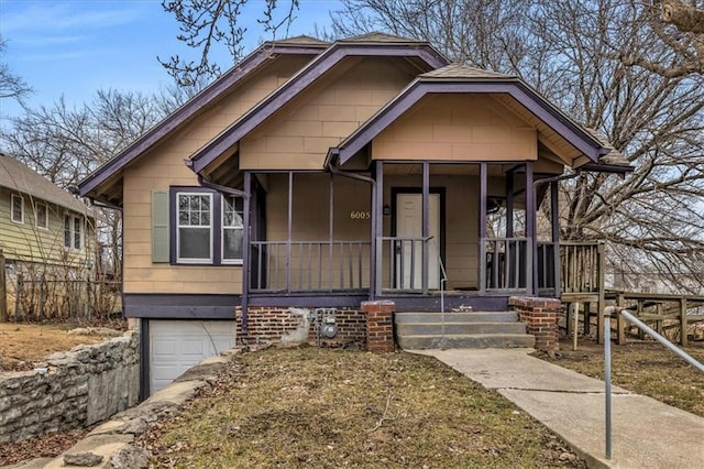 6005 Forest Ave, Kansas City, MO 64110 - bungalow featuring an attached garage and a porch
