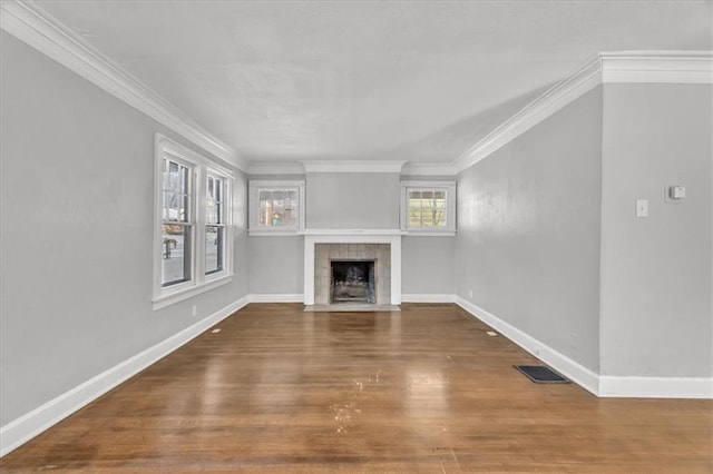 unfurnished living room with baseboards, a fireplace, visible vents, and wood finished floors