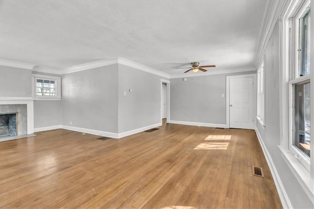 unfurnished living room with baseboards, a fireplace, visible vents, and light wood-style floors