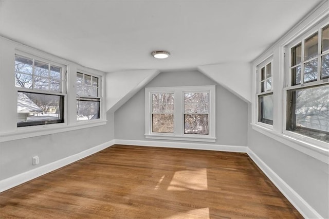 bonus room with vaulted ceiling, wood finished floors, and baseboards