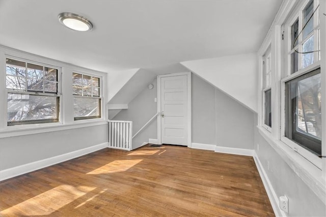 additional living space featuring lofted ceiling, wood finished floors, and baseboards