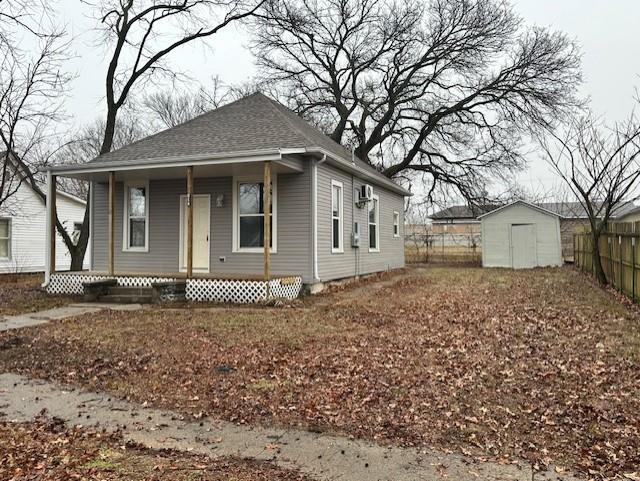 view of front facade with a storage shed and a porch