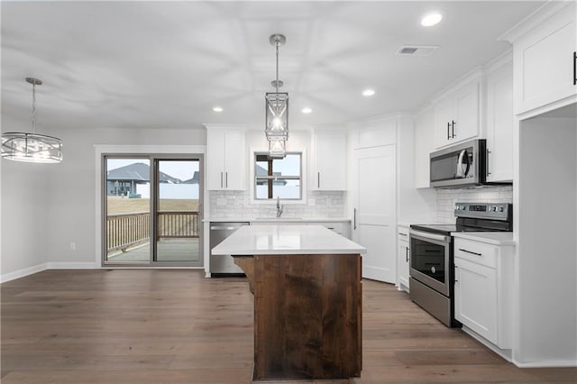 kitchen featuring pendant lighting, sink, a kitchen island, and appliances with stainless steel finishes