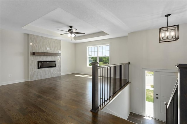 1320 N Holland Ct, Independence, MO 64056 - foyer entrance with a tray ceiling, wood finished floors, ceiling fan, and a tile fireplace