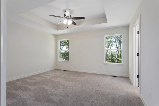 1320 N Holland Ct, Independence, MO 64056 - carpeted empty room with a tray ceiling, healthy amount of natural light, and a ceiling fan