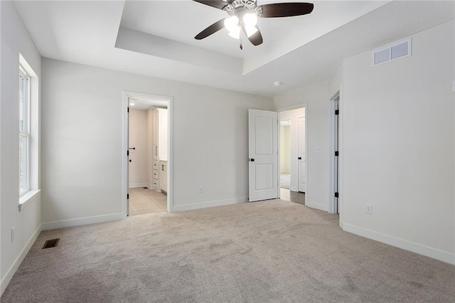 1320 N Holland Ct, Independence, MO 64056 - unfurnished bedroom with light colored carpet, a raised ceiling, and ensuite bathroom