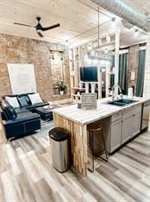 218/220 N Main St, Maryville, MO 64468 - bar with sink, gray cabinets, light hardwood / wood-style floors, brick wall, and decorative light fixtures