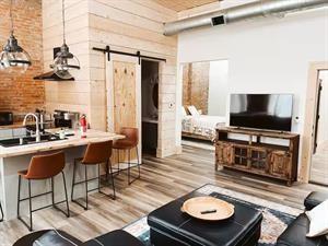 218/220 N Main St, Maryville, MO 64468 - living room featuring a barn door, light hardwood / wood-style flooring, and a high ceiling