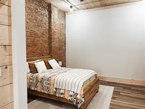 218/220 N Main St, Maryville, MO 64468 - bedroom featuring brick wall and hardwood / wood-style floors