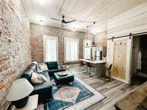 218/220 N Main St, Maryville, MO 64468 - living room with ceiling fan, hardwood / wood-style floors, brick wall, wooden ceiling, and a barn door