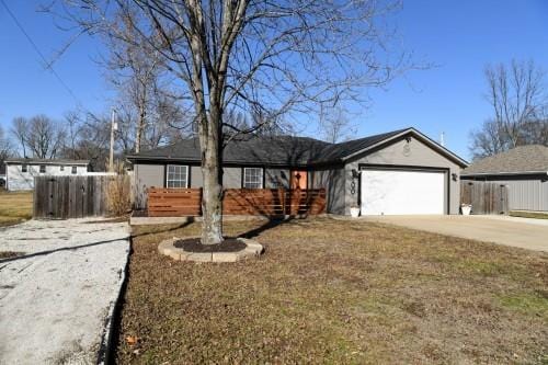 ranch-style house featuring a garage and a front lawn