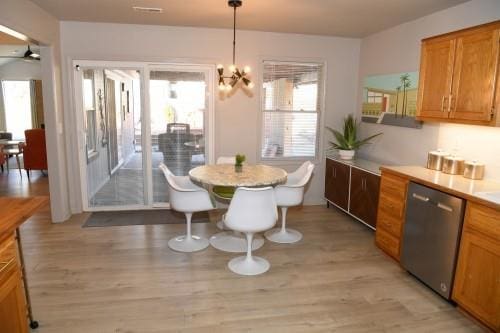 dining area with a notable chandelier and light hardwood / wood-style flooring