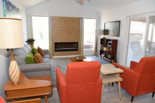 living room featuring lofted ceiling, a wealth of natural light, and a fireplace