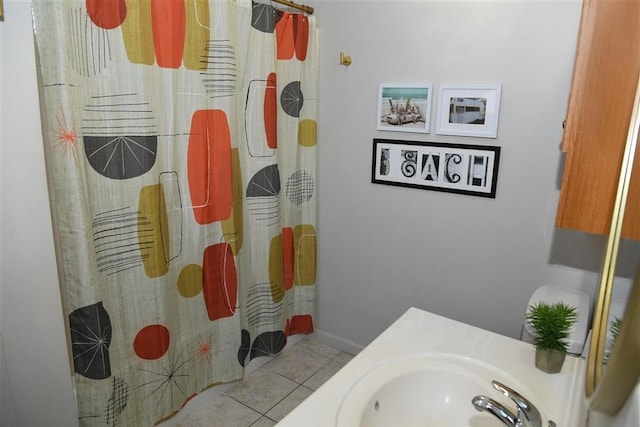 bathroom with sink, curtained shower, and tile patterned floors