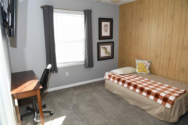 bedroom featuring wooden walls and carpet floors