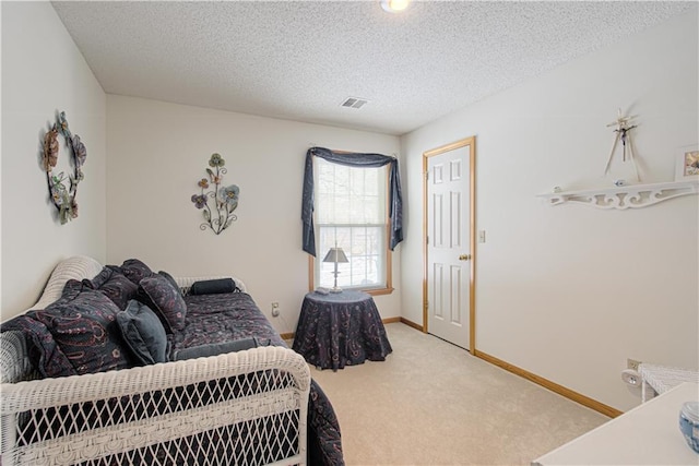 carpeted bedroom with visible vents, a textured ceiling, and baseboards