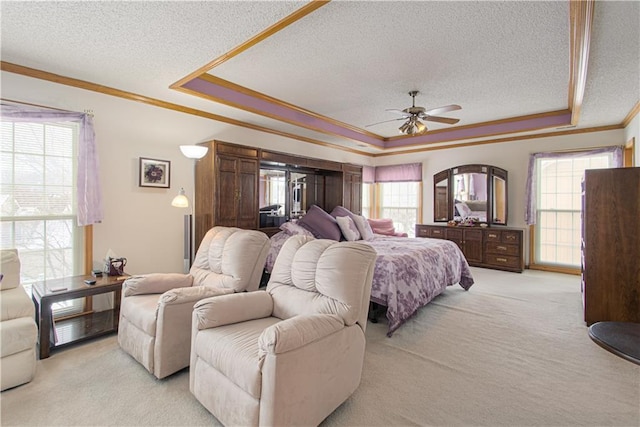 bedroom with light carpet, multiple windows, ornamental molding, and a raised ceiling