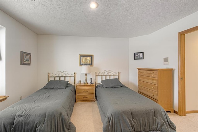 bedroom featuring light carpet and a textured ceiling