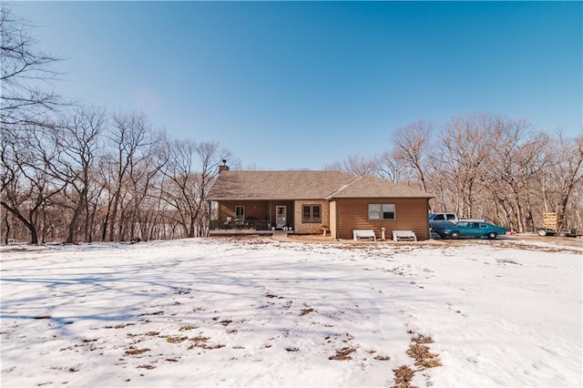 snow covered property featuring a chimney