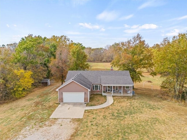 view of front of house featuring a porch, a garage, and a front yard