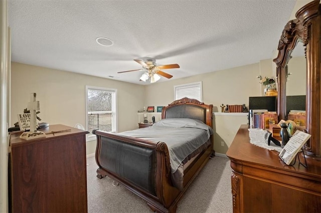 carpeted bedroom featuring ceiling fan and a textured ceiling