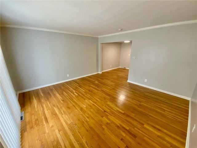 spare room featuring hardwood / wood-style flooring and crown molding