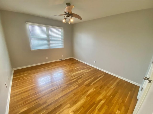 empty room with ceiling fan and light hardwood / wood-style floors