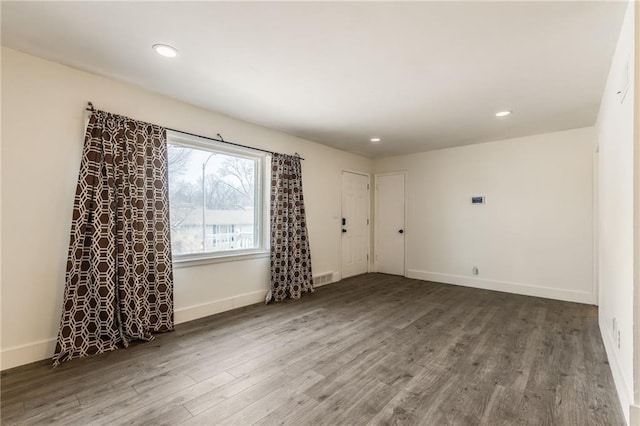 empty room with dark hardwood / wood-style flooring