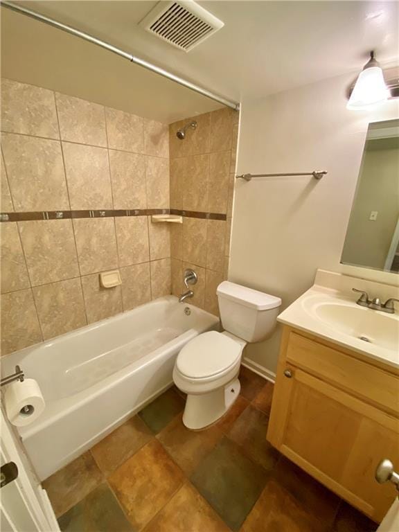 full bathroom featuring tiled shower / bath, vanity, and toilet