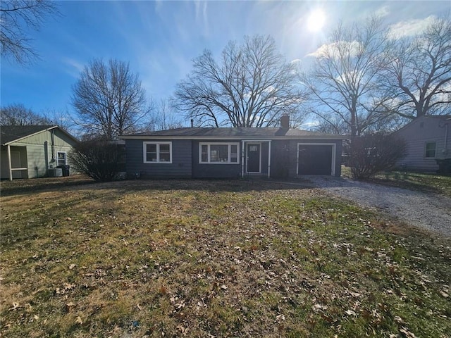 single story home featuring a garage and a front lawn