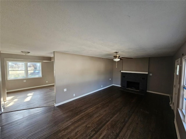 unfurnished living room with ceiling fan, dark hardwood / wood-style floors, and a textured ceiling