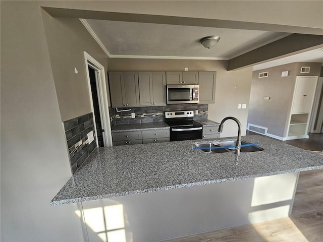 kitchen with gray cabinetry, sink, kitchen peninsula, and appliances with stainless steel finishes