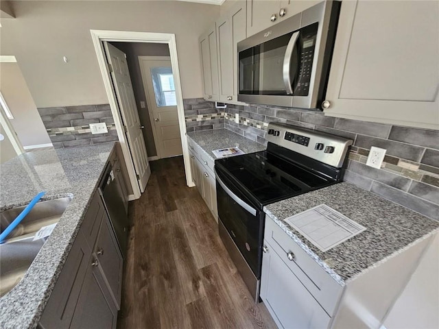 kitchen featuring light stone counters, white cabinetry, and stainless steel appliances