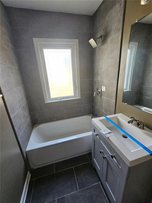 bathroom featuring vanity, tile patterned floors, and tiled shower / bath