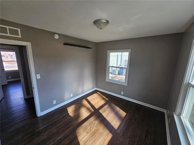 empty room featuring dark hardwood / wood-style floors and a healthy amount of sunlight