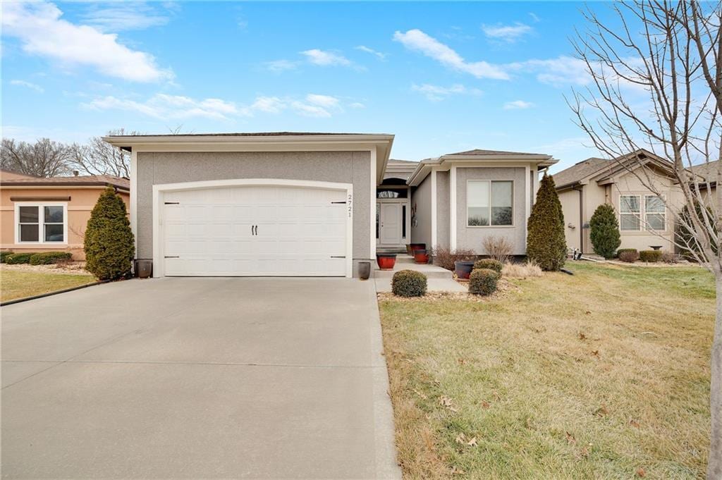 single story home featuring a garage and a front lawn