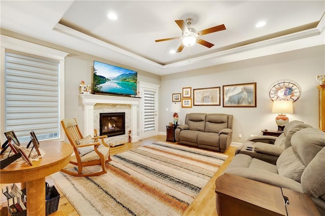 living room featuring hardwood / wood-style floors, a tray ceiling, and ceiling fan