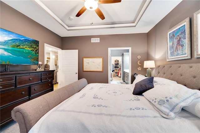 bedroom featuring ceiling fan, a tray ceiling, a closet, and a spacious closet