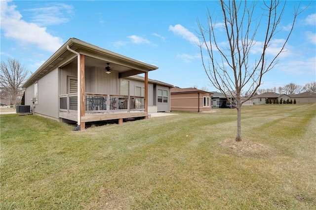 back of house featuring central AC, a lawn, and ceiling fan