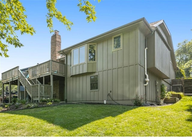 back of house with a wooden deck and a yard