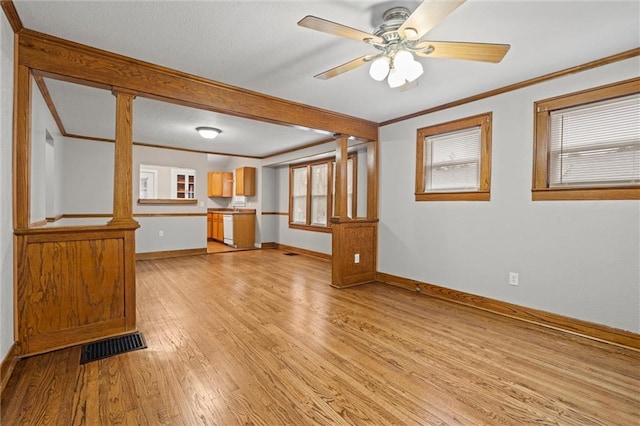 unfurnished living room with crown molding, light hardwood / wood-style flooring, ceiling fan, and ornate columns