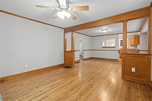 spare room with ornamental molding, light hardwood / wood-style flooring, decorative columns, and ceiling fan