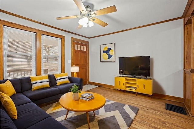 living room with crown molding, ceiling fan, and light wood-type flooring