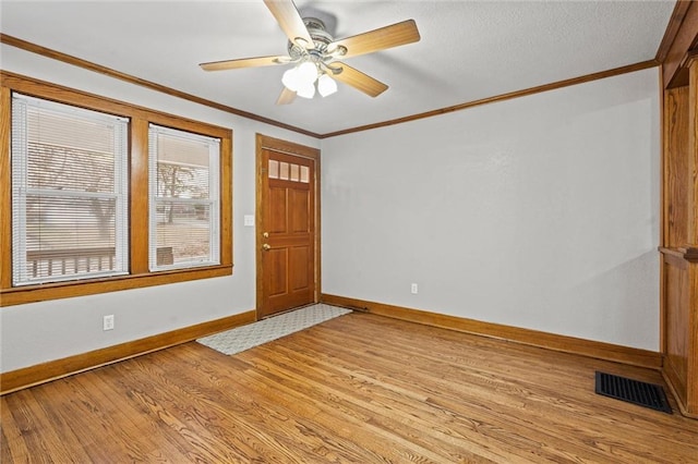 foyer with ceiling fan, ornamental molding, and light hardwood / wood-style floors