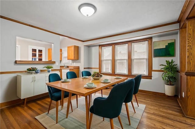 dining room featuring crown molding and light hardwood / wood-style flooring