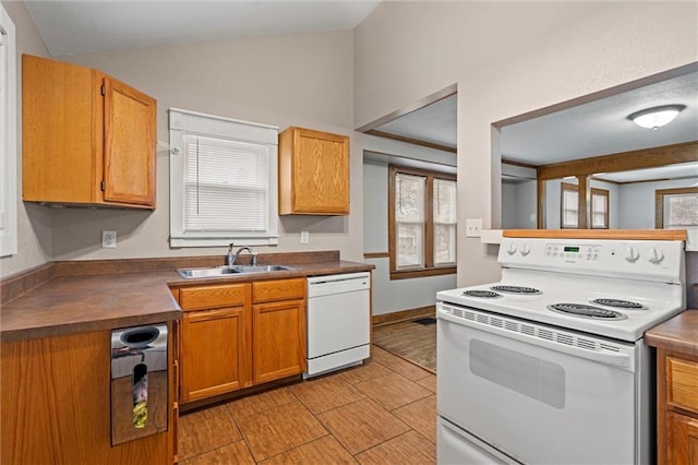 kitchen with vaulted ceiling, sink, and white appliances