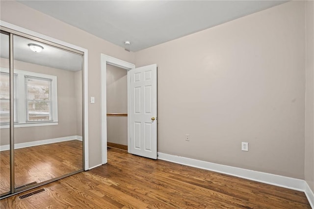 unfurnished bedroom with hardwood / wood-style flooring and a closet